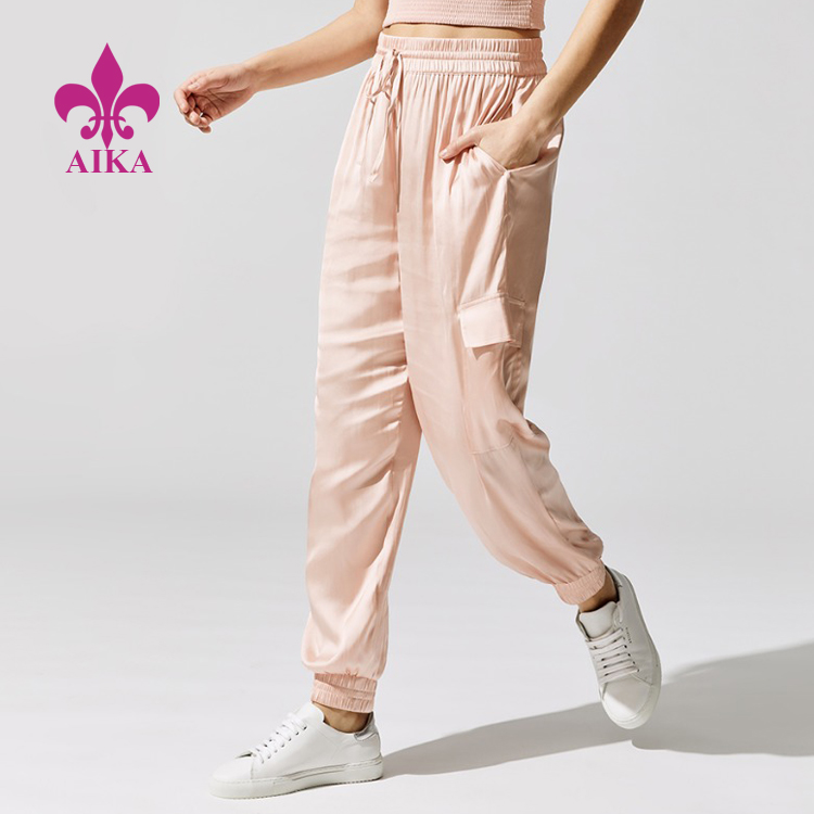 اپنی مرضی کے کھیلوں کے لباس کے لیے مینوفیکچرر - ہلکے وزن کا کسٹم لوگو کھیلوں کا لباس ڈراسٹرنگ کمر خواتین کارگو جیبی ساٹن جوگر - AIKA