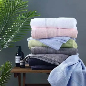Cotton terry bath towel with satin border and e...