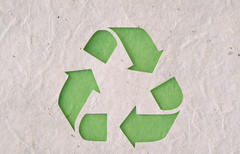 રિસાયકલ કરેલા કાગળ પર રિસાયક્લિગ પ્રતીક