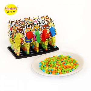 Фауресија дува балони-играчка со модел на крава со шарени бонбони