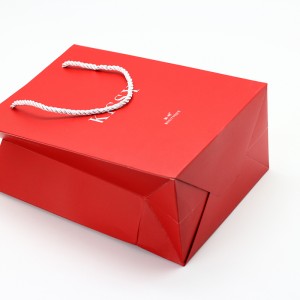 Papierová taška s matnou lamináciou v červenej farbe s prispôsobenou nylonovou rukoväťou