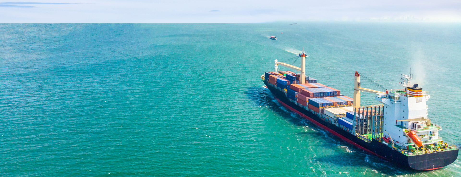Вид с воздуха на грузовые суда, которые курсируют посреди моря и перевозят контейнеры в порт.Импортно-экспортная и транспортная логистика и международные перевозки морским транспортом.