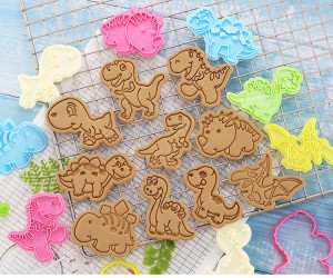 Biscotti di muffa di biscotti di dinosauri di cartoni animati 3d pressendu u muffa di cottura in casa biscotti di cottura chì giranu a glassa