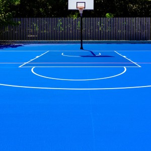 Basketball court in an outdoor park, with intense midday sun, no
