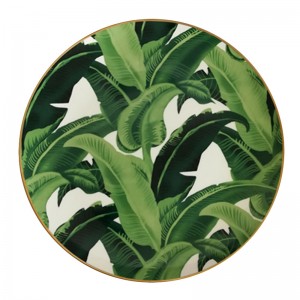 Zielone talerze z porcelany kostnej ze złotym brzegiem i wzorem w liście bananowca na wesele