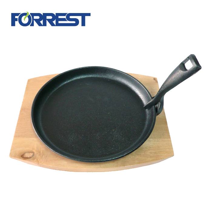 Cast iron skillet sizzling plate with wooden base