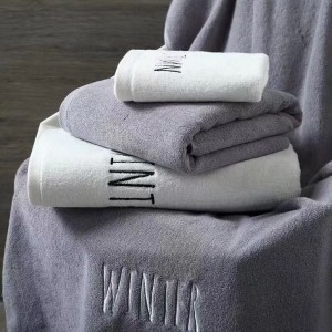 Cotton terry bath towel with satin border and embroidery