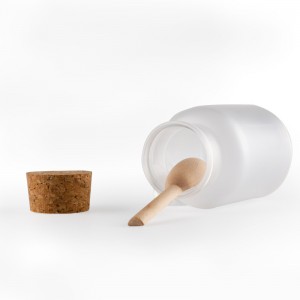 Plastikowa butelka soli do kąpieli z korkiem i małą drewnianą łyżką