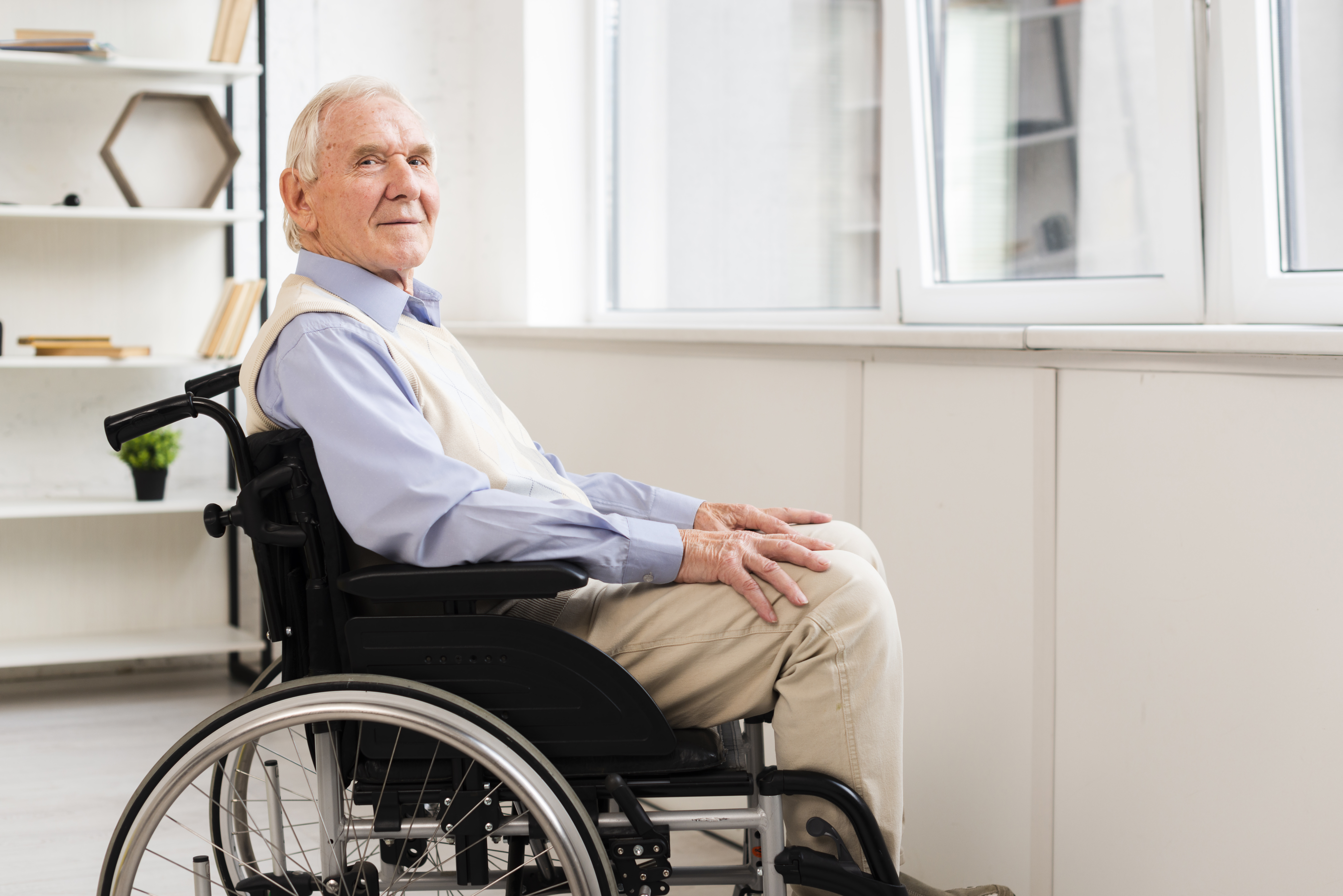 widok z boku-starszy-siedzący-wózek inwalidzki